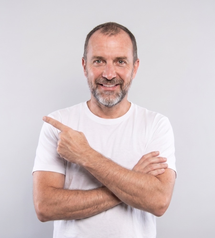 A smiling man in a white t-shirt pointing towards the talentpool registration form